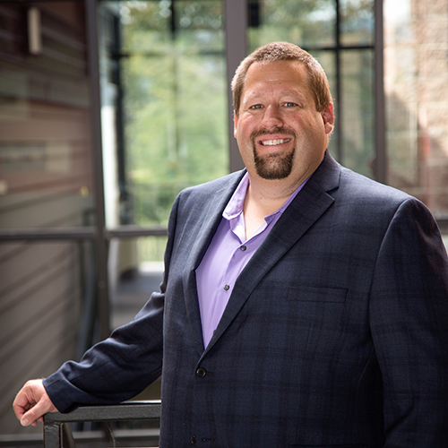 An image of John Hurlbut, Realtor Standing In Front of an Office Building.